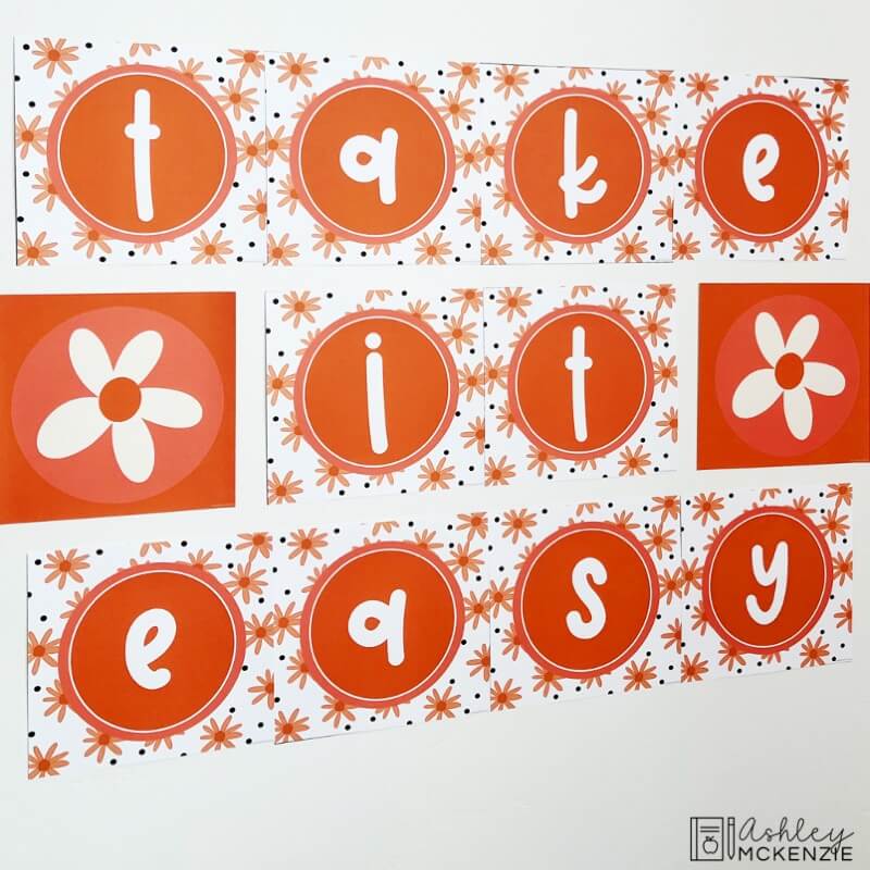 A classroom wall decorated with a large daisy themed wall display and the saying "Take it easy"