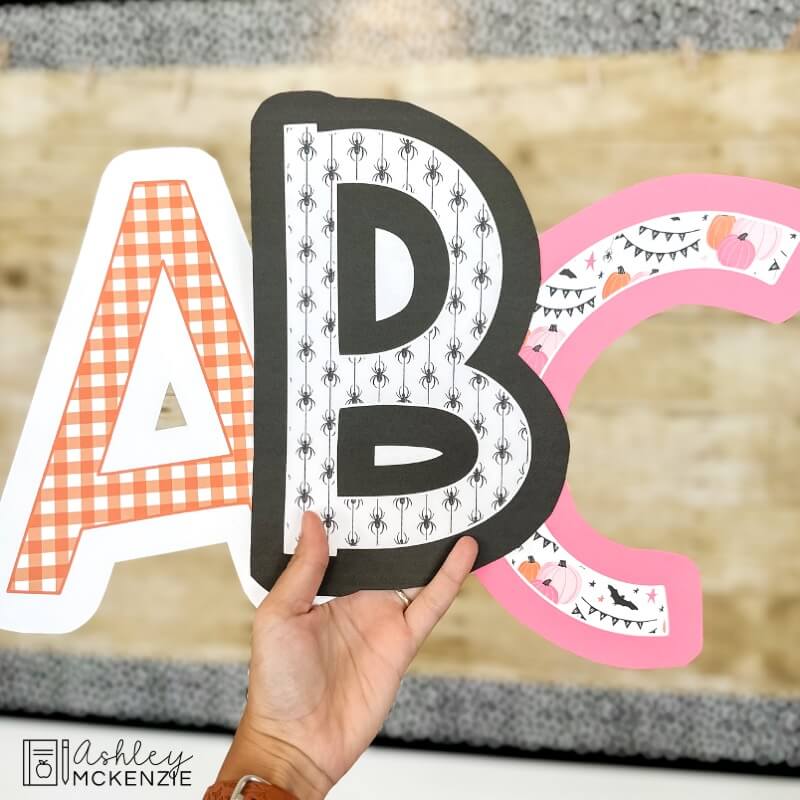 Large bulletin board letters are shown in a halloween design theme, upper case letters A, B, and C are held up