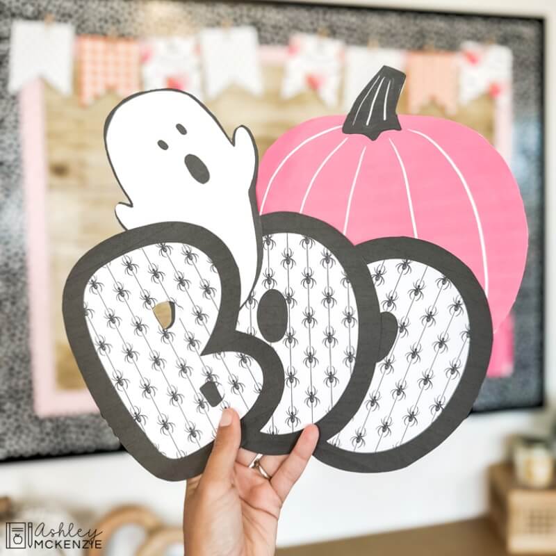 Halloween classroom decor cutouts are shown, including a ghost, a pink pumpkin, and the letters to spell BOO