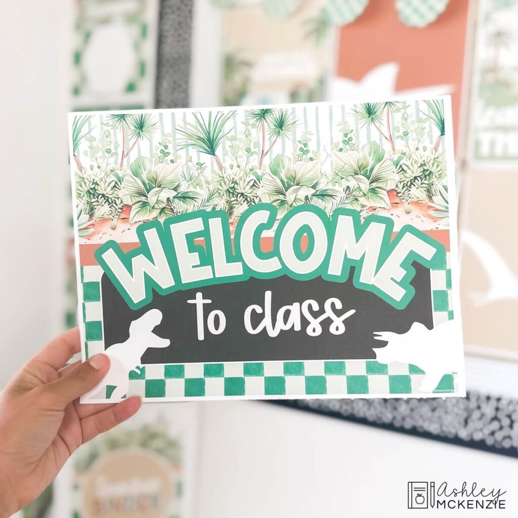 A classroom welcome sign in a modern dinosaur decor theme that says "Welcome to class"