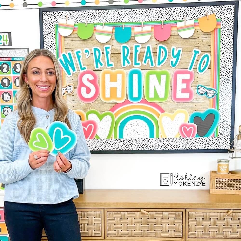 A classroom bulletin board decorated with a bright neon classroom decor theme, featuring the saying "We're Ready to Shine"