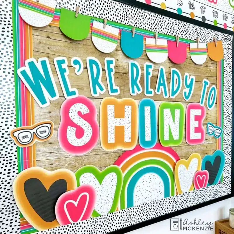 A classroom bulletin board is decorated for back to school with a bright neon theme