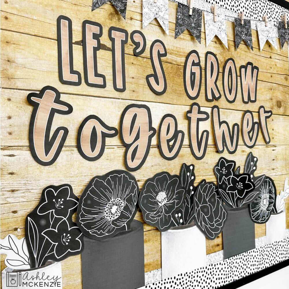 Black and white classroom decor is featured on a classroom bulletin board with the saying "let's grow together"