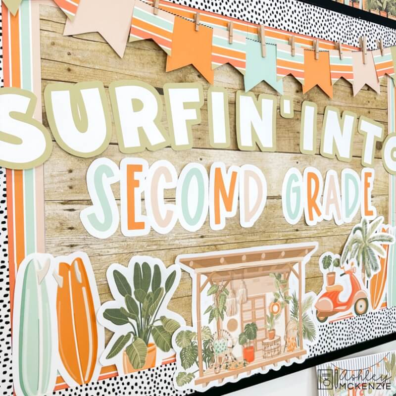 Boho tropical beach designs decorate a bulletin board with the saying "Surfin' into Second Grade"