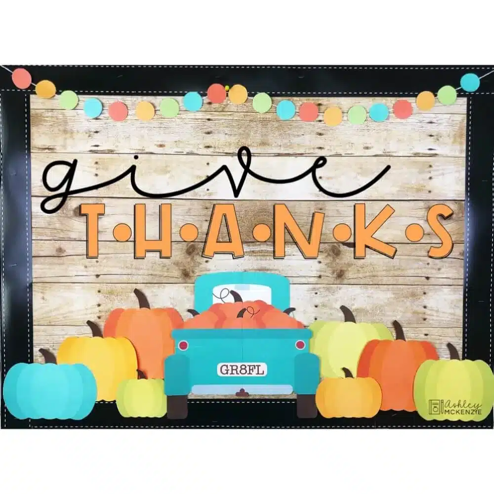 A Thanksgiving classroom display that features a classic blue truck surrounded by a variety of pumpkins and the saying "Give Thanks"