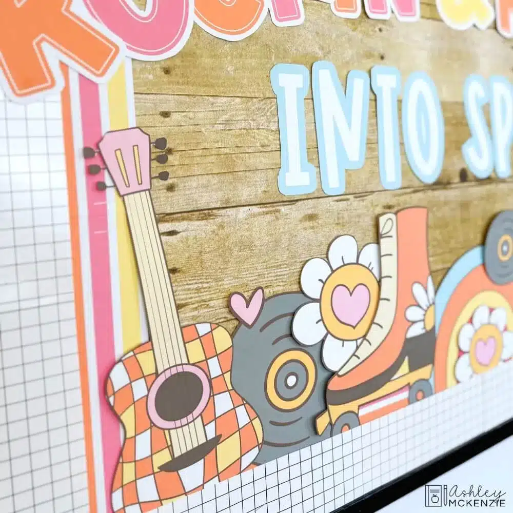 A closeup of a spring bulletin board idea featuring cutouts of guitars, vinyl records, roller skates, daisies and a rainbow.