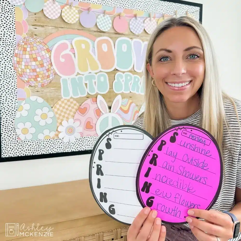 A teacher holding up egg-shaped cutouts of a spring acrostic poem template for students to create