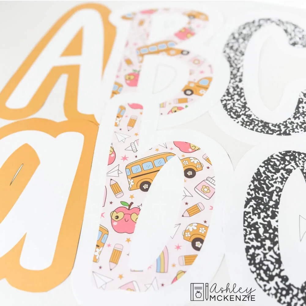 Primary friendly font bulletin board letters are shown in upper and lower case letters featuring school supplies themed prints and solid colors.