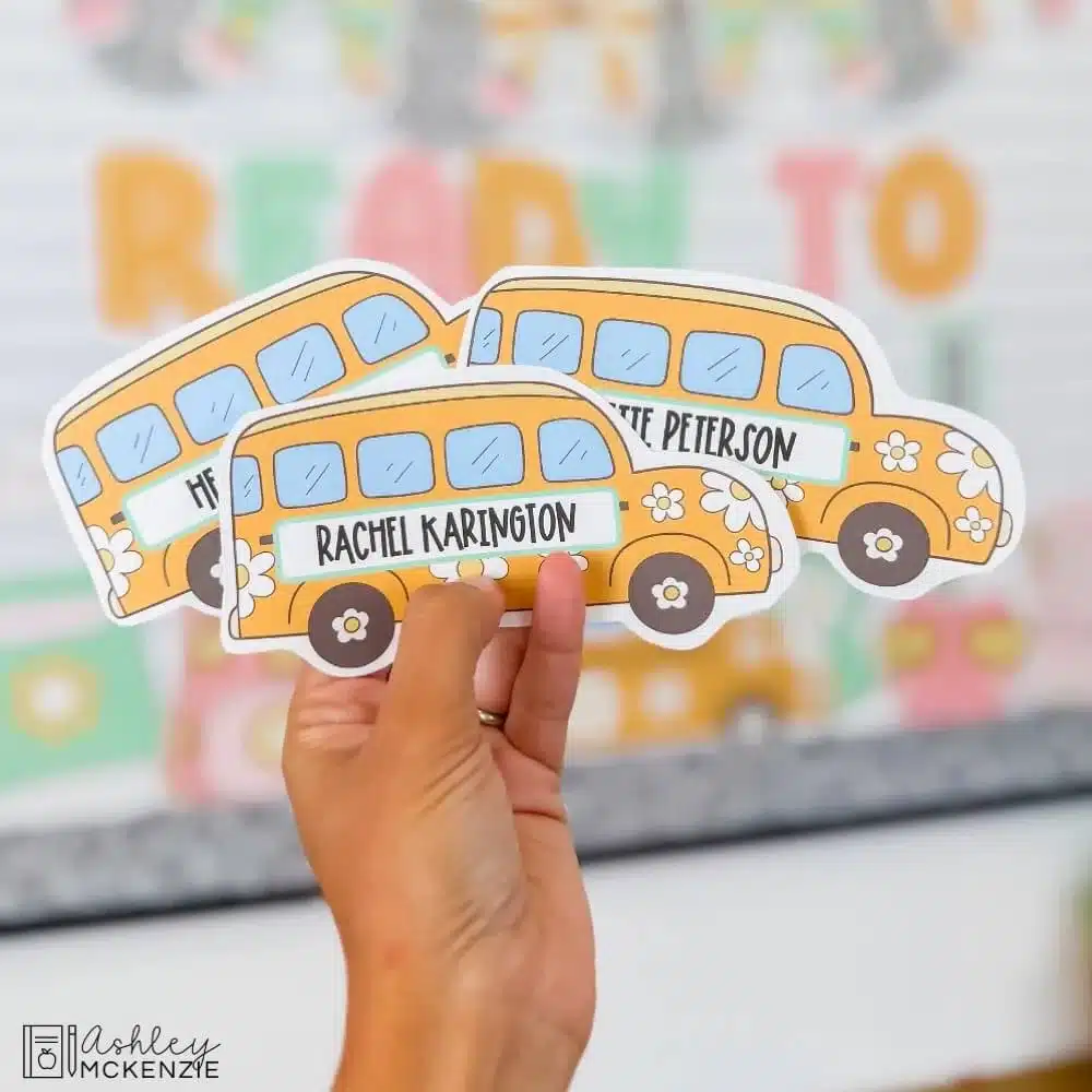Little cutouts of school buses are shown featuring students' names typed on them to add to back to school bulletin board displays